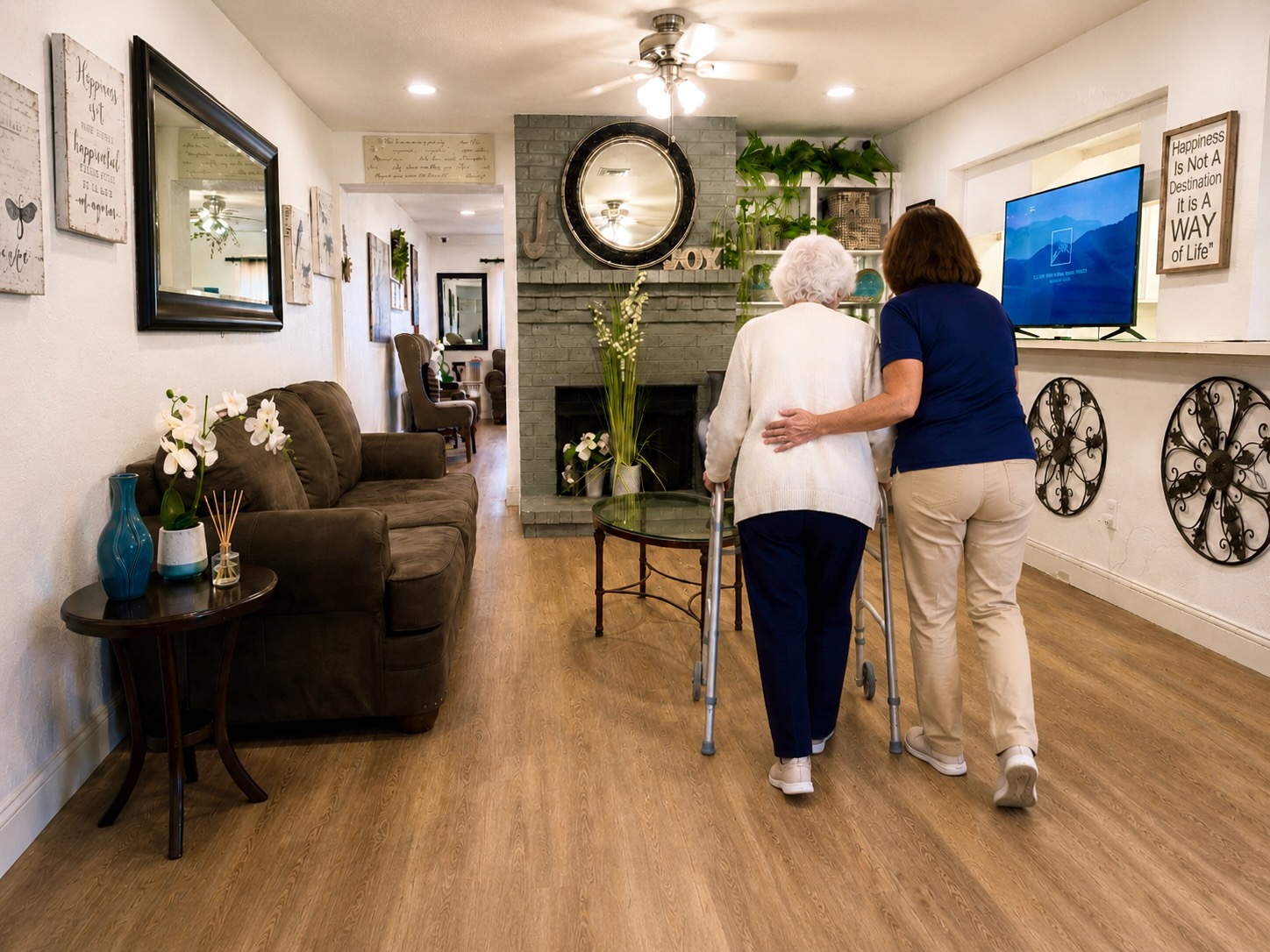 Caregiver walking beside a resident inside a warm residential care home